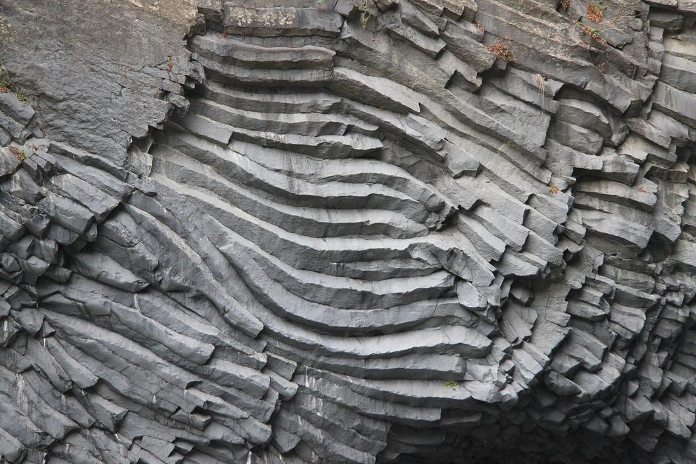 A cliff of tightly packed polygonal basalt columns, formed as a thick lava flow cooled and contracted.