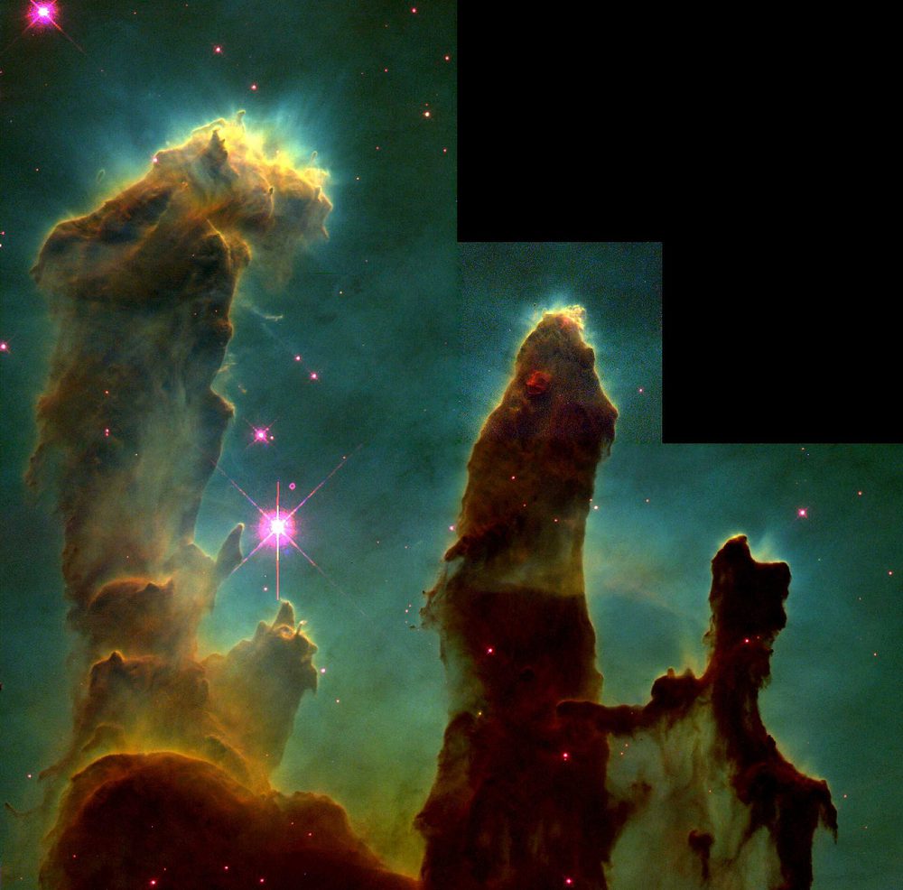 Three towering columns of dark gas and dust silhouetted against glowing background gas, with new stars forming inside them.
